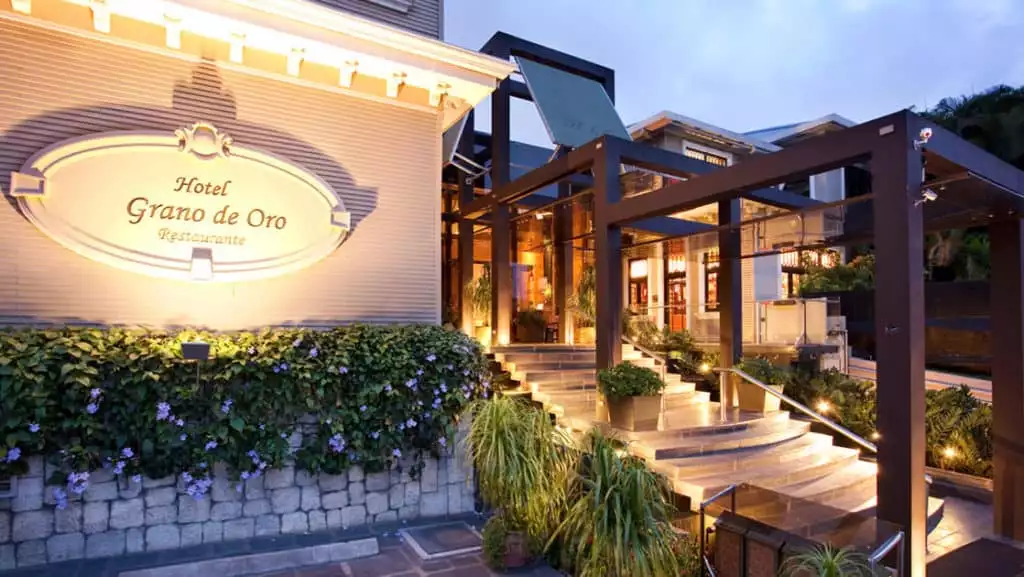 The entrance to Hotel Grano de Oro in San Jose, Costa Rica, is a renovated, elegant, Victorian mansion with steps and landscaping.