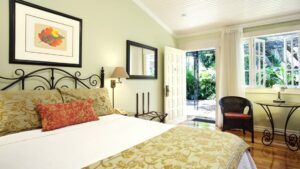 The superior room at Hotel Grano de Oro with a large, comfortable bed, fresh linens, and windows with a view of the jungle in Costa Rica