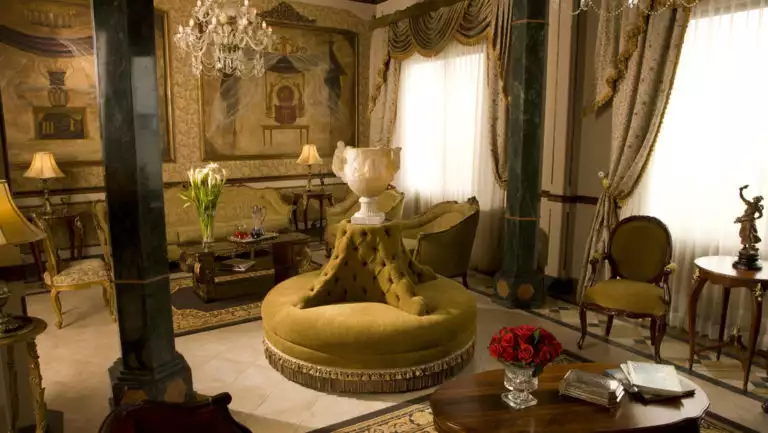 The lobby with a circular couch, fine art, a chandelier, drapes, and flowers at Mansion del Rio, a premier boutique hotel in Guayaquil, Ecuador