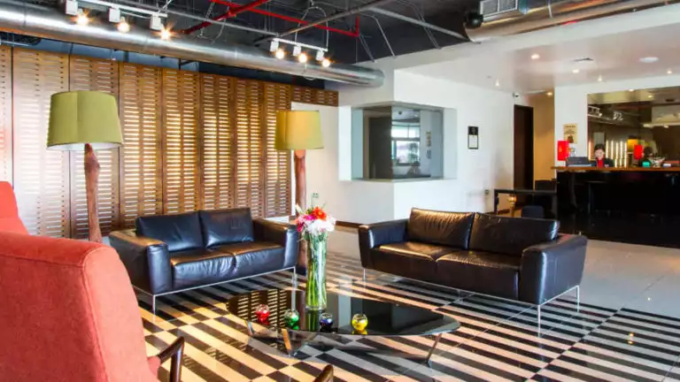 With a couch, reading lamps, and modern accent furniture, the lobby greets guests at the Park Inn by Radisson, located in San Jose, Costa Rica