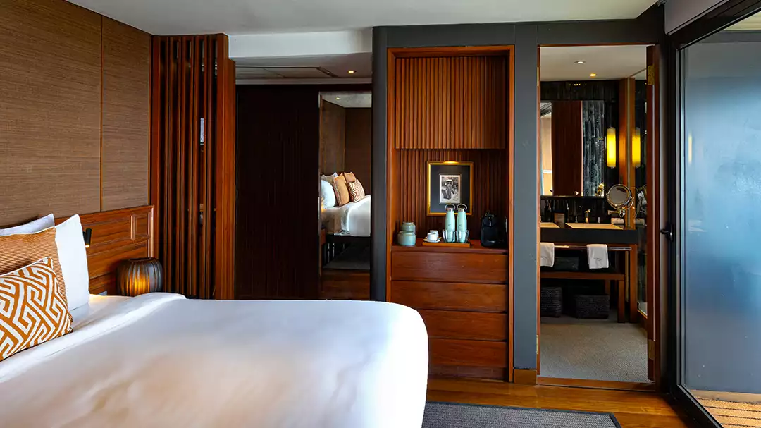 A beautiful suite on the second deck of the Aqua Mekong featuring a large bed with light linens and great views of the Mekong