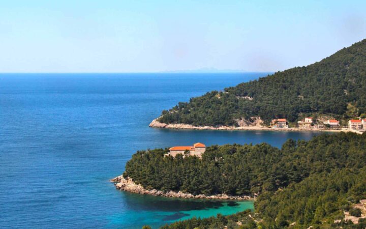 winding mediterranean coastline with different shades of water on a sunny day