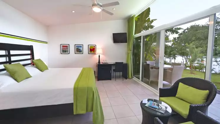A guest room with a queen bed and sliding glass doors has a panoramic view at the Bocas del Mar hotel in Panama
