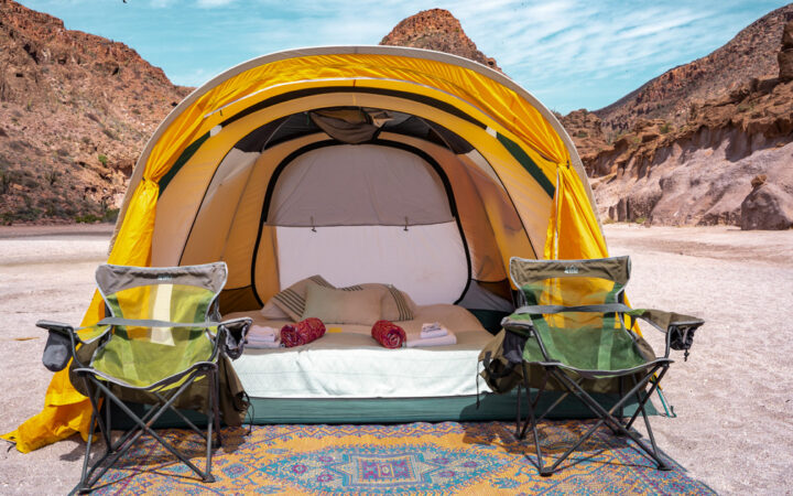 Yellow tent with queen-sized air bed, sheets & blankets, exterior woven mat & 2 camp chairs at Camp Cecil de la Isla, Baja.