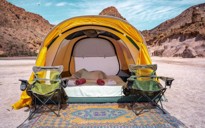 Yellow tent with queen-sized air bed, sheets & blankets, exterior woven mat & 2 camp chairs at Camp Cecil de la Isla, Baja.