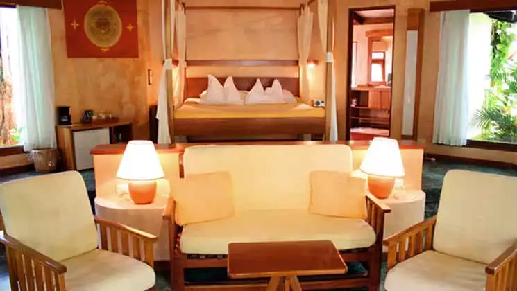 Guests at Hotel Capitán Suizo at Playa Tamarindo, Costa Rica can relax in a suite in the jungle with a queen-sized bed, canopy, and sitting area