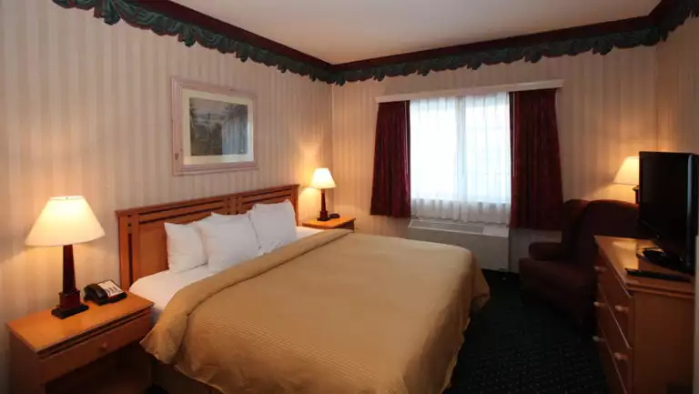 Room with king bed, nightstands, dresser and TV at Clarion Suites in Anchorage