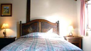 Room interior with bed, bedside tables, lamps and window at Hotel Antigua Miraflores in Peru