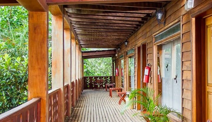 A covered porch in front of the rooms at the Hotel Heliconia in Costa Rica offers guests jungle views and opportunities for birdwatching