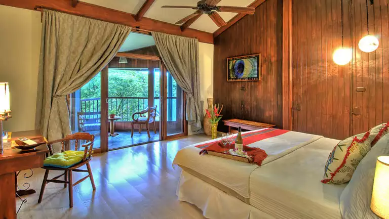 The Forest View Balcony Room with a king-sized bed, a private terrace, and views of the cloud forest at the Monteverde Lodge, a sustainable, nature retreat iin Costa Rica