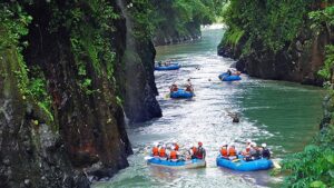 Rafters float down Costa Rica’s Pacuare River between steep cliffs and lush vegetation.