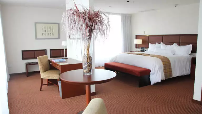 The imperial room at Casa Andina Private Collection Miraflores with one queen-sized bed and a sitting area with a table that is close to Lima, Peru