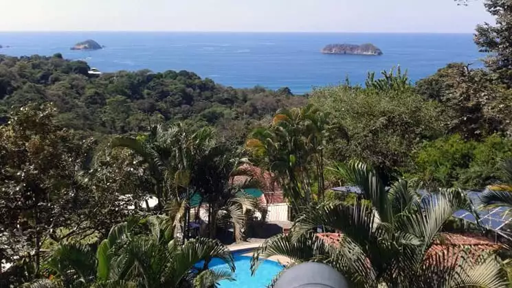 An aerial view of Si Como No, a sustainable resort on Costa Rica's Pacific Coast, surrounded by lush jungle and ocean views.