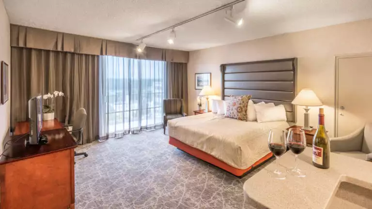 A suite with a king-sized bed, private terrace, and two glasses of red wine at the Westmark Anchorage, a downtown hotel that was recently renovated