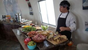 A server with a table of buffet foods at Arctic Watch Lodge.