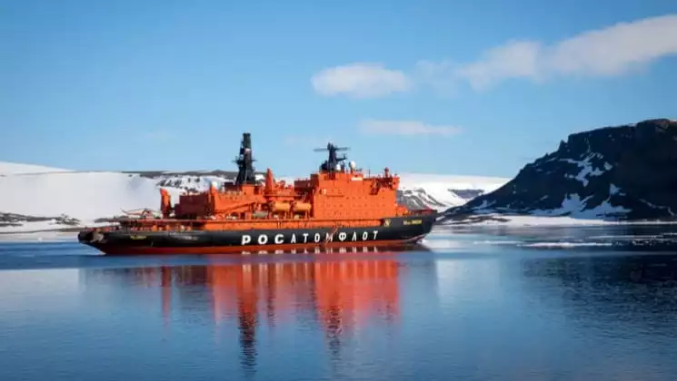 50 Years of Victory sailing in Antarctica with glaciers, mountain range and ice floating on the water.