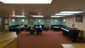 Sitting room with books, tables, benches, chairs and game table.