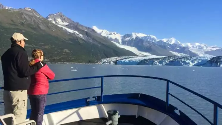 Man and woman at bow looking at distant mountains aboard Discovery classic working yacht in Alaska