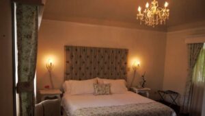 Chandelier hangs over bed in room at Finca Lerida Lodge in Panama