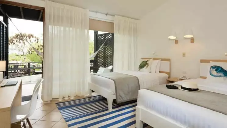 Room with full-size beds at Finch Bay Eco Hotel