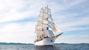 Sea Cloud luxury small ship sailing toward the viewer on calm waters on an overcast day