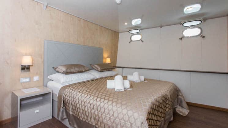 Adriatic Sun cabin with large bed and small portholes.