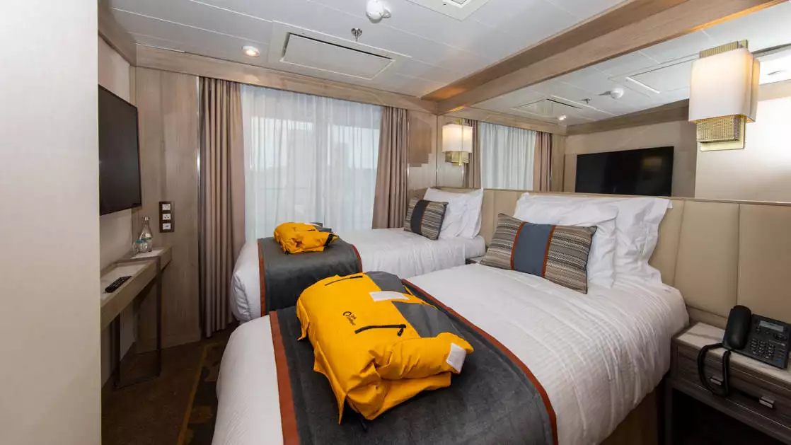 World Explorer triple cabin with seating area, bathroom, desk and beds.