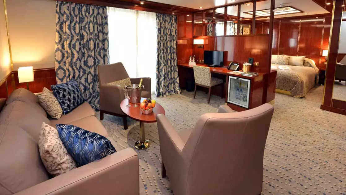 Hebridean Sky Owner's suite with separate queen bedroom and living area with couch, chair, coffee table and desk.