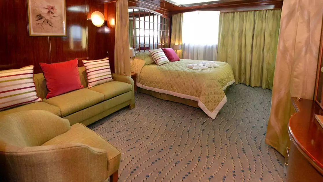 Hebridean Sky Window suite with queen bed, couch and living room with large window.