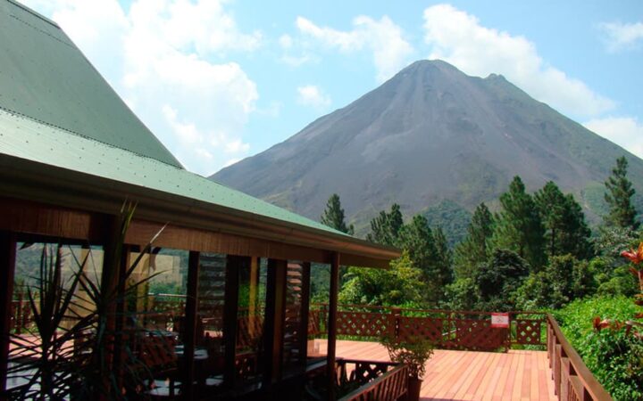 Sunny deck of main lodge at Arenal Observatory Costa Rica Lodge with Arenal Volcano in background
