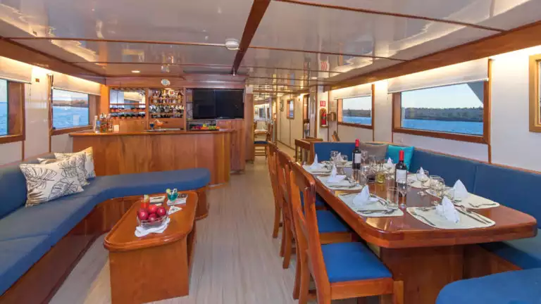 Salaon with big couch, table, and bar aboard Beluga.