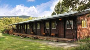 A row of wood cabins that are located near a river at the Brooks Lodge in Alaska