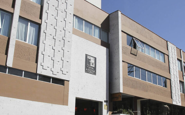 The exterior of the Casa Andina Standard Arequipa, a comfortable Peruvian hotel built with contemporary construction using white volcanic stone.