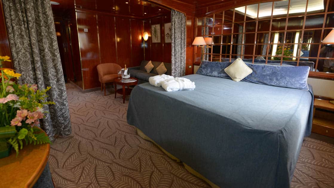 Island Sky Window suite with queen bed, living room with couch, chair and coffee table.