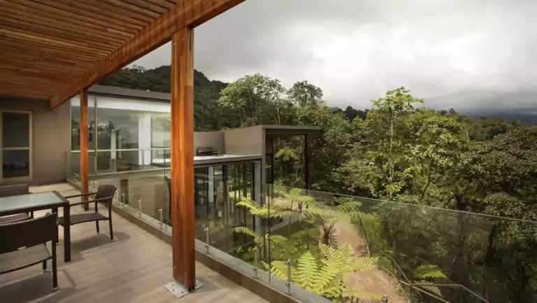 Tables and chairs on a patio overlooking the forest during a cloudy day at the Mashpi eco Lodge, near Quito, Ecuador