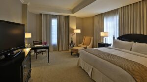 The deluxe room at the Panama Bristol Hotel with a king-sized bed, lounge chairs, and a flat-screen TV