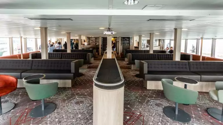 plancius polar expedition ship lounge with couches and tables filling the room and windows on the end