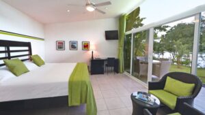 A guest room with a queen bed and sliding glass doors has a panoramic view at the Bocas del Mar hotel in Panama