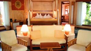 Guests at Hotel Capitán Suizo at Playa Tamarindo, Costa Rica can relax in a suite in the jungle with a queen-sized bed, canopy, and sitting area