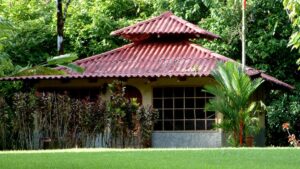 Palm trees and tropical plants surrounding a window-filled bungalow at Casa Corcovado Jungle Lodge in Costa Rica