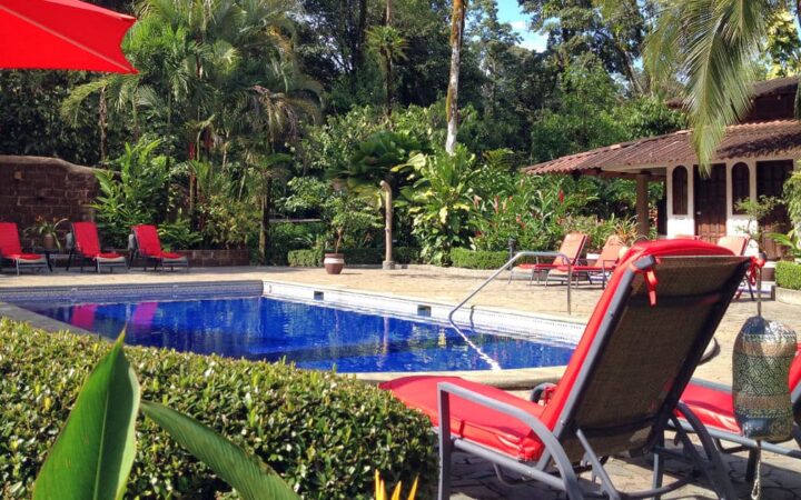 Large pool with lounge chairs and shady umbrellas at Casa Corcovado Jungle Lodge in Costa Rica