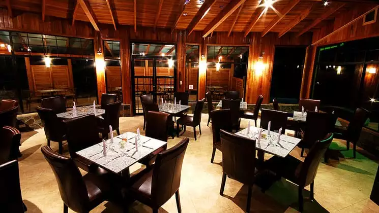 casa grande bambito dining room with tables, chairs and wooden accents on the walls and ceiling