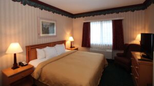 Room with king bed, nightstands, dresser and TV at Clarion Suites in Anchorage