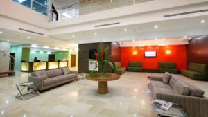 lobby at the clarion victoria panama hotel with marble floor, accent colors against muted tones and a large flowering plant on a table in the middle