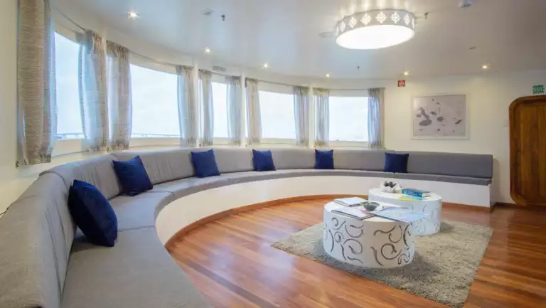 Lecture room with large wrap around bench couch aboard Galapagos Horizon ship.