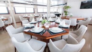 Infinity dining room with tables and chairs set up for a meal and large picture windows.
