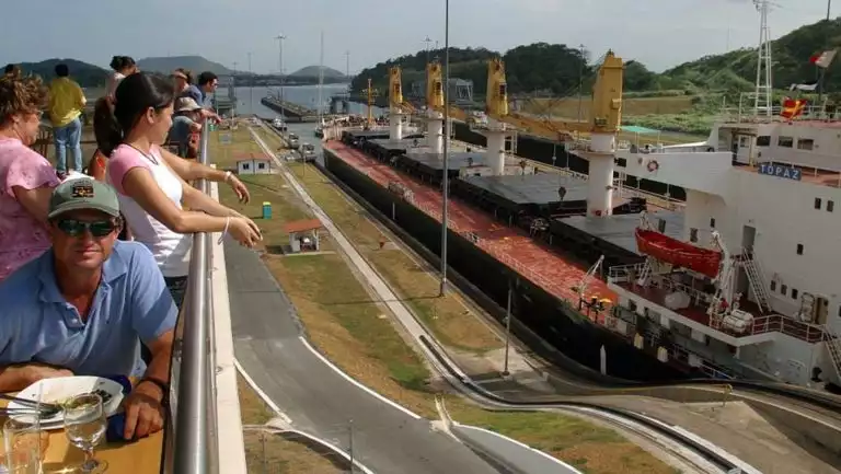 adventure travelers relax and watch small ships travel through the miraflores locks during the Panama Discovery land tour