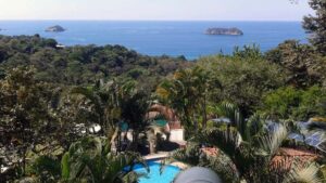 An aerial view of Si Como No, a sustainable resort on Costa Rica's Pacific Coast, surrounded by lush jungle and ocean views.