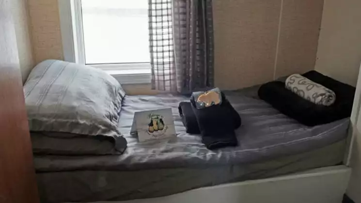 Lower bunk cabin with towels and a welcome note on the bed in the Tundra Lodge.
