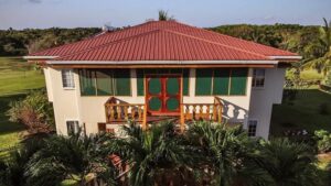 The Garden Villa at Turneffe Flats with red roof and small porch on second floor.